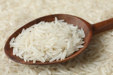 Photo of Raw basmati rice and spoon as background, closeup