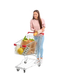 Photo of Young woman with full shopping cart on white background
