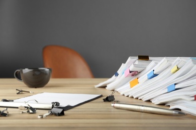 Photo of Stack of documents with binder clips on wooden table
