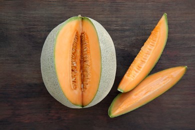 Cut delicious ripe melon on wooden table, flat lay