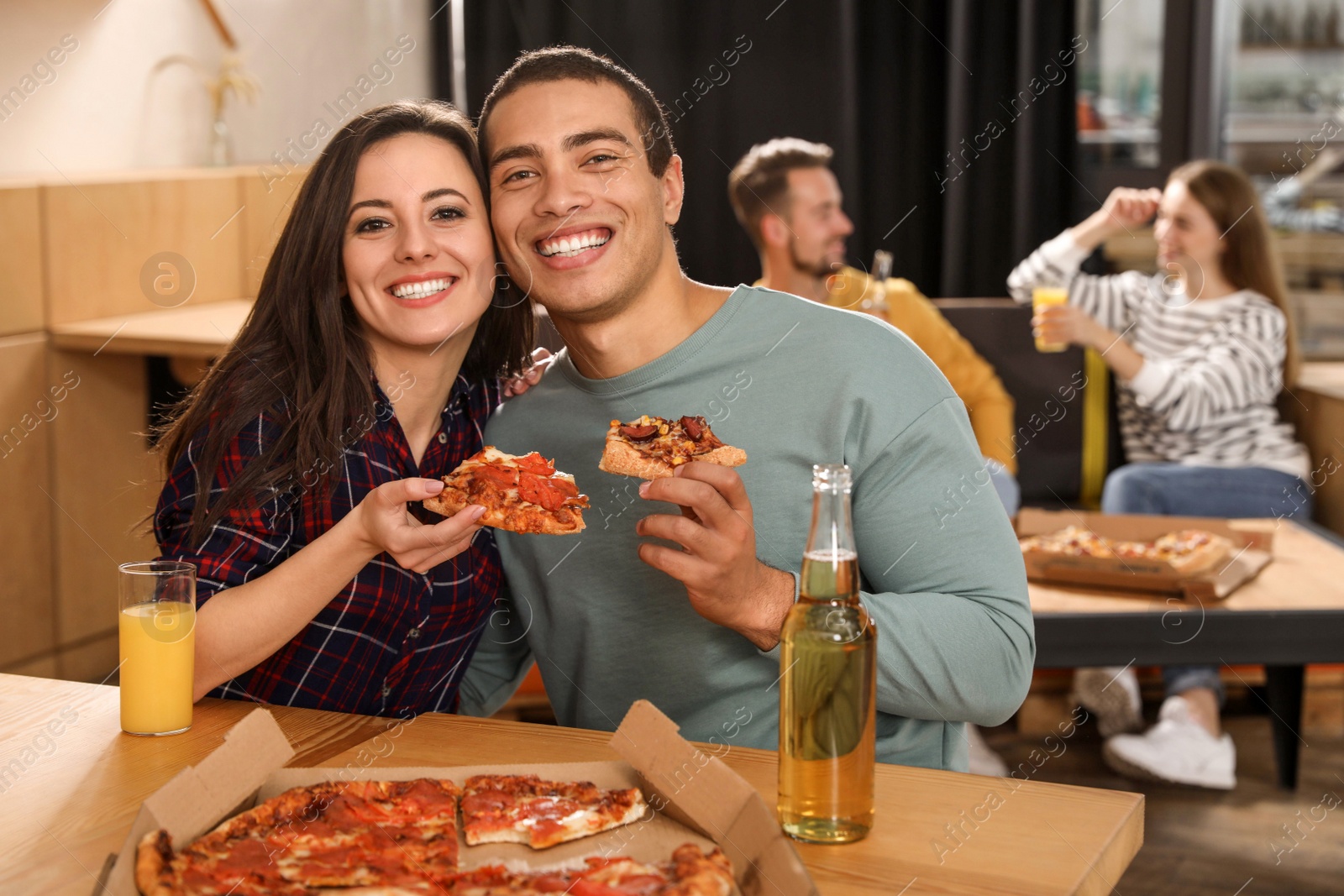 Photo of Young couple eating delicious pizza in cafe