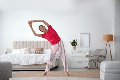 Photo of Young woman doing gymnastics at home. Morning fitness