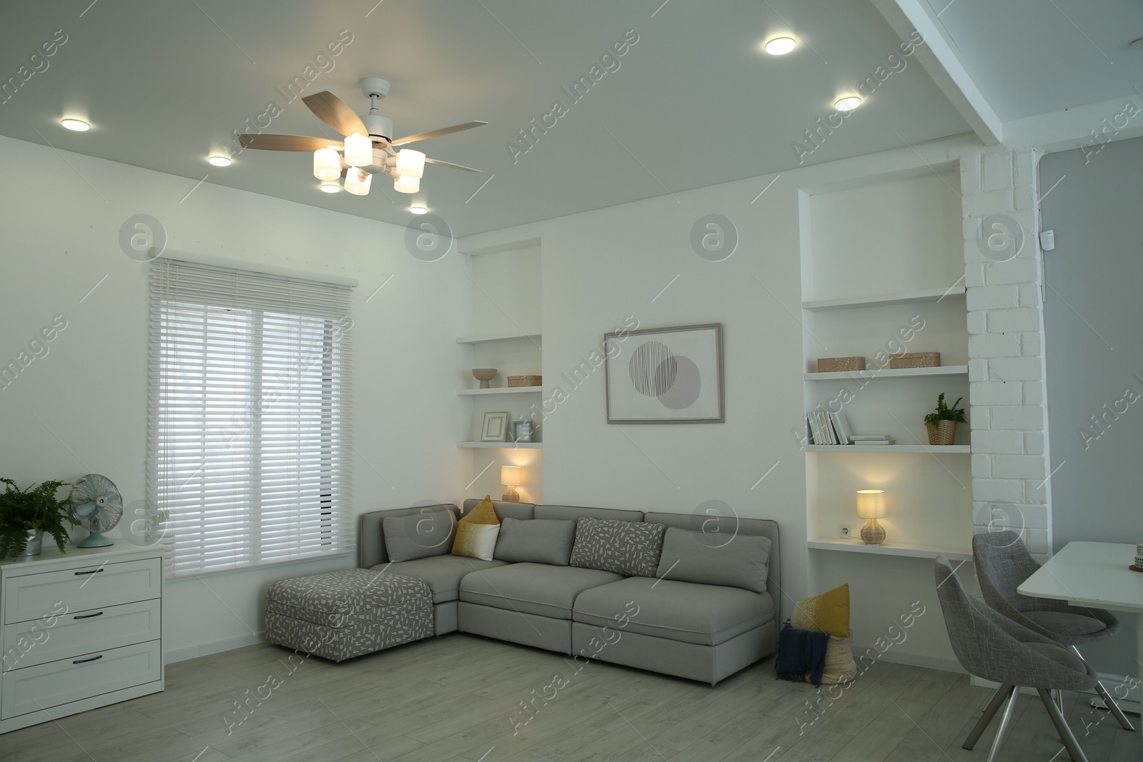 Photo of Comfortable furniture, ceiling fan and accessories in stylish living room