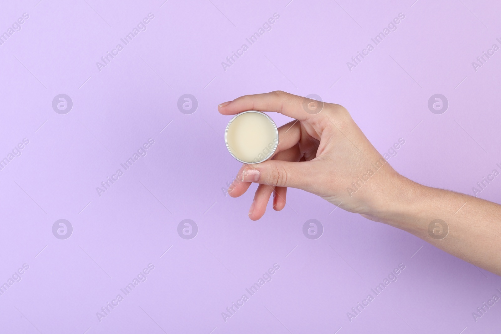 Photo of Woman with lip balm on violet background, closeup