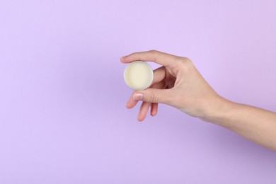 Photo of Woman with lip balm on violet background, closeup