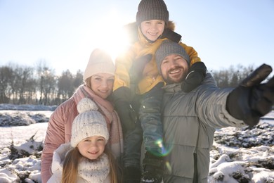 Photo of Happy family spending time together in sunny snowy park