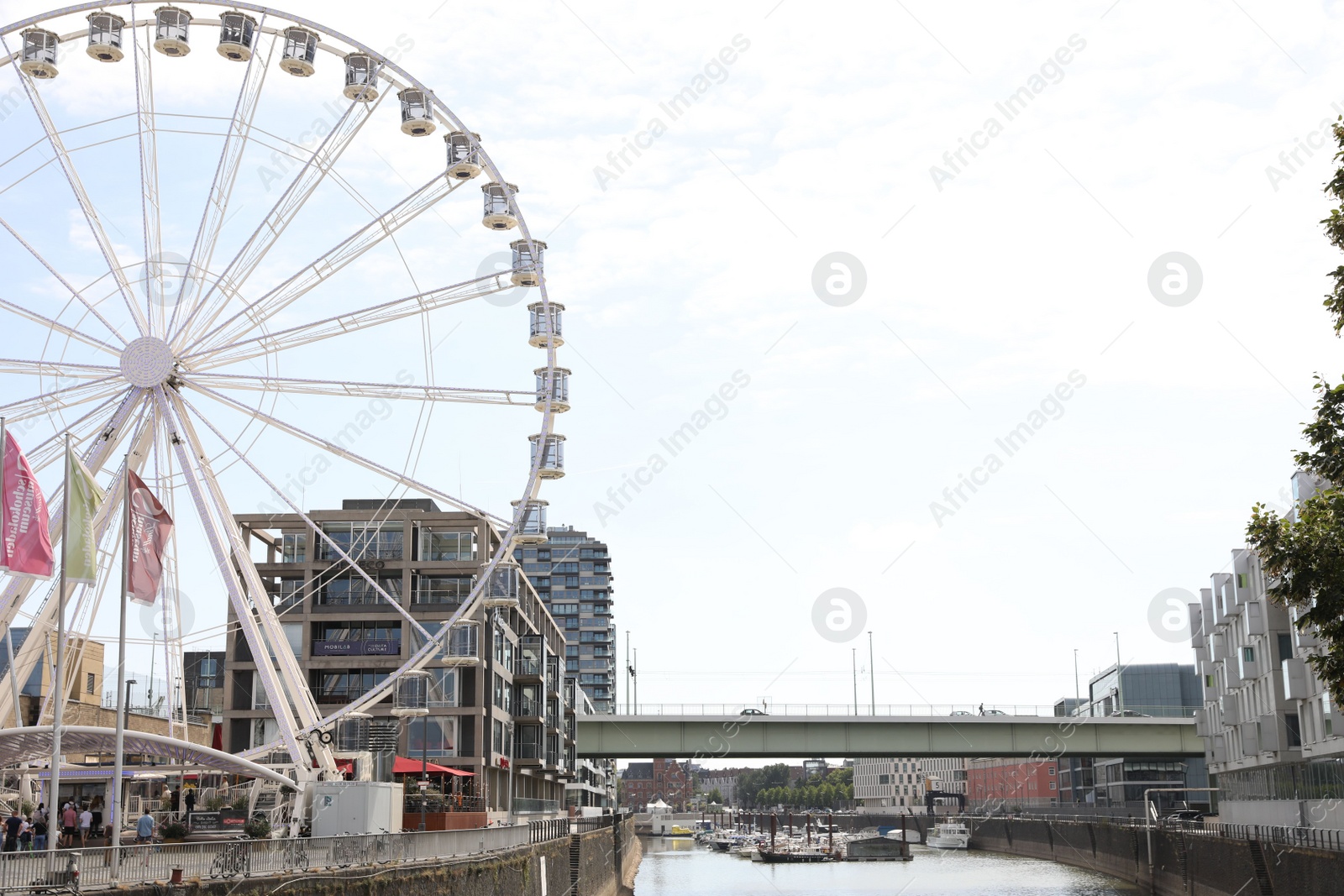 Photo of Cologne, Germany - August 28, 2022: Picturesque view of Ferris wheel in city near canal