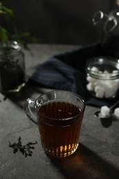 Photo of Tasty hot tea in cup on grey table, closeup