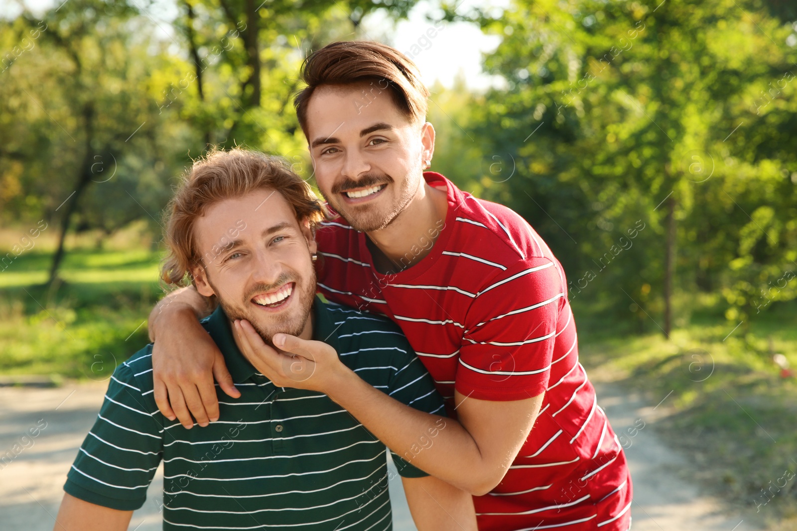 Photo of Portrait of happy gay couple smiling in park