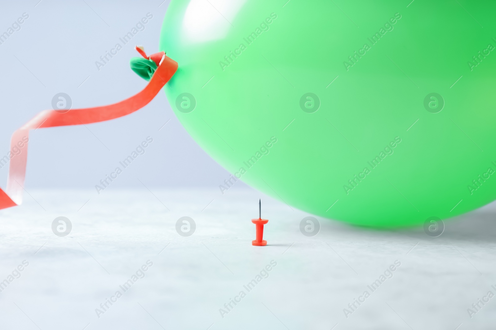 Photo of Color balloon and pin on table against white background, space for text