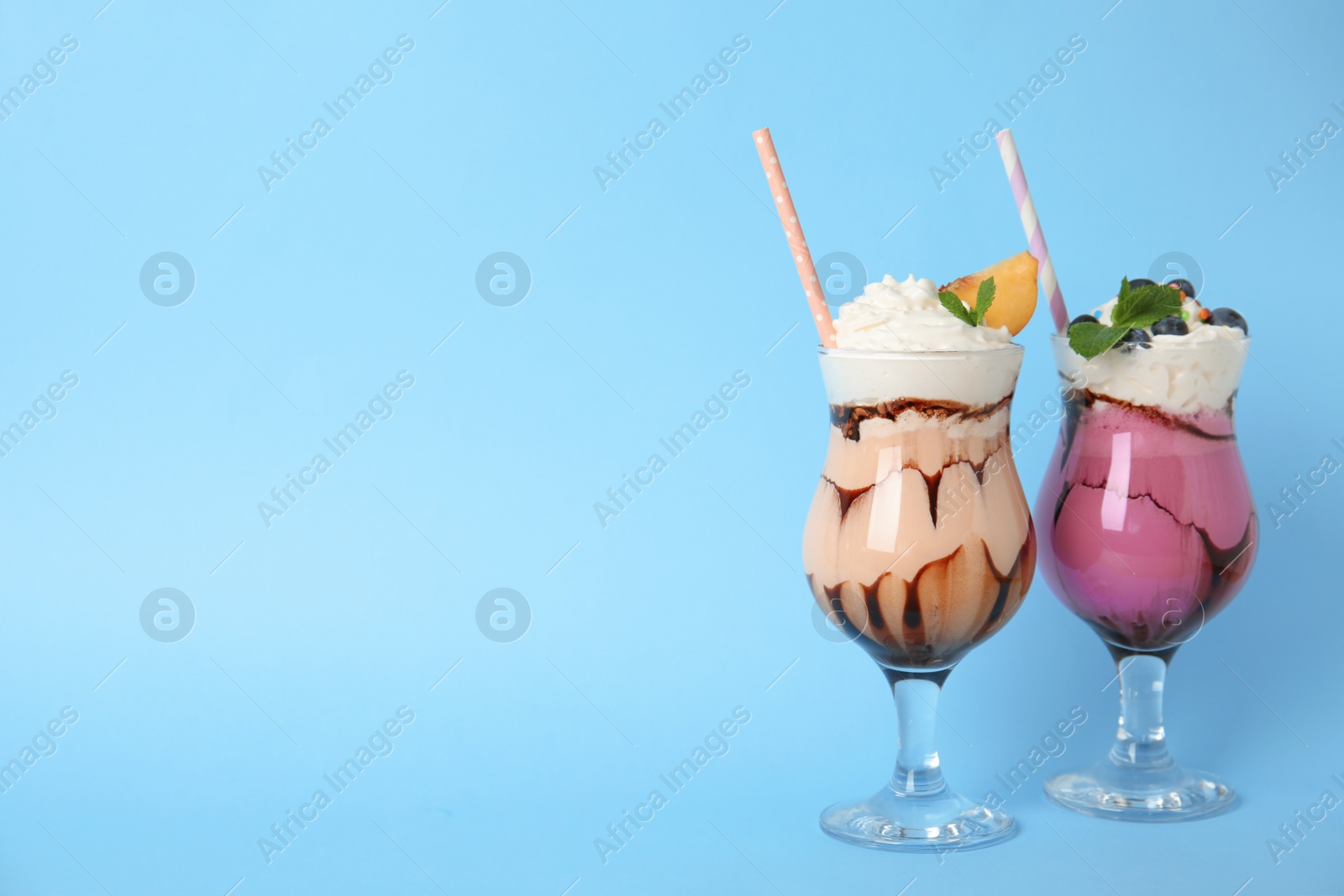 Photo of Glasses of tasty milk shakes and space for text on color background