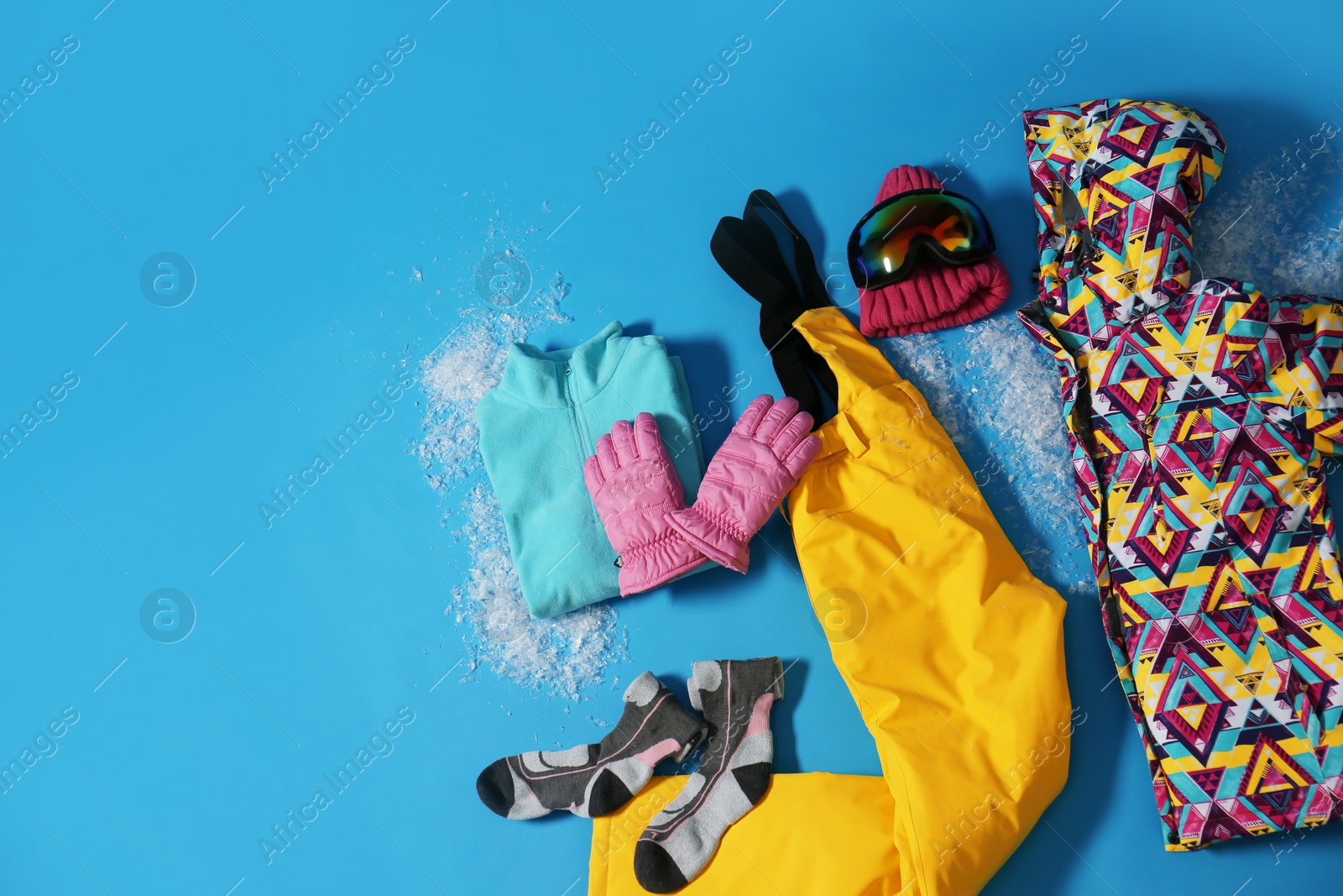 Photo of Stylish winter sport clothes on light blue background, flat lay