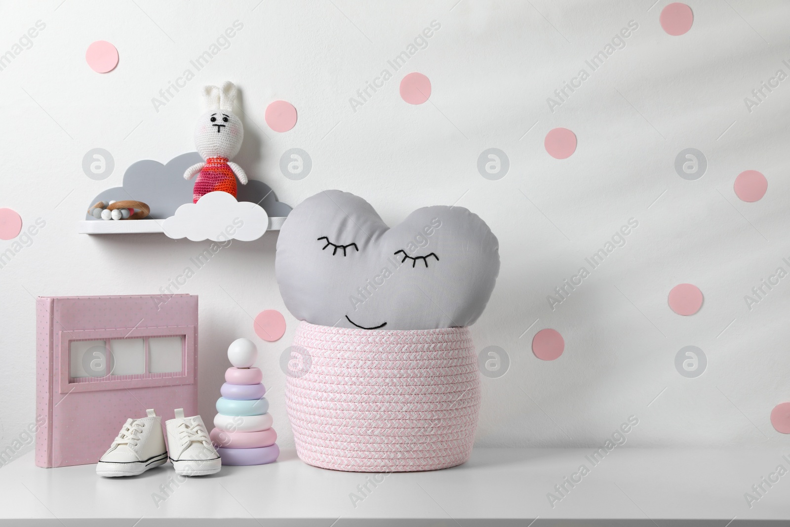 Photo of Album, baby shoes and toys on chest of drawers indoors, space for text. Children's room interior