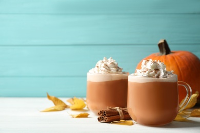 Photo of Delicious pumpkin latte on white table. Space for text