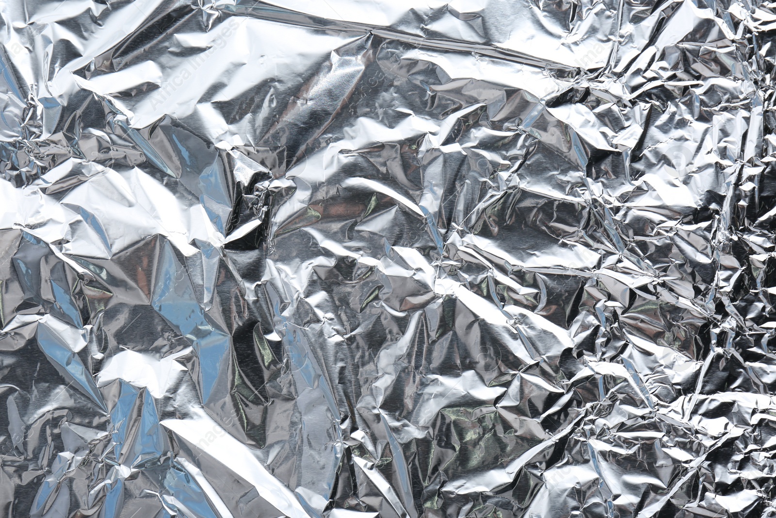 Photo of Crumpled silver foil as background, closeup view