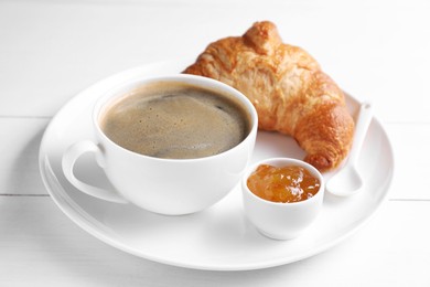 Photo of Fresh croissant, jam and coffee on white wooden table. Tasty breakfast