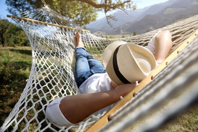 Young man resting in hammock outdoors on sunny day