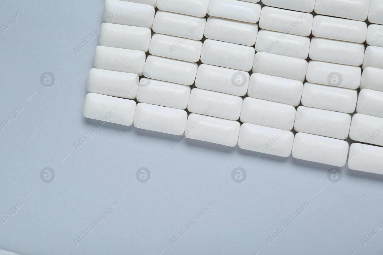 Photo of Tasty white chewing gums on light grey background, flat lay. Space for text