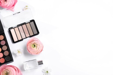 Flat lay composition with different makeup products and beautiful spring flowers on white background, space for text