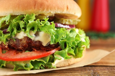 Photo of Delicious burger with beef patty and lettuce on table, closeup. Space for text