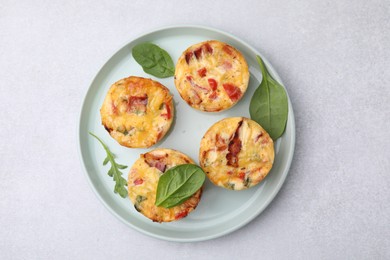 Freshly baked bacon and egg muffins with cheese on light gray table, top view