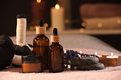 Composition with spa products and burning candles on soft light surface