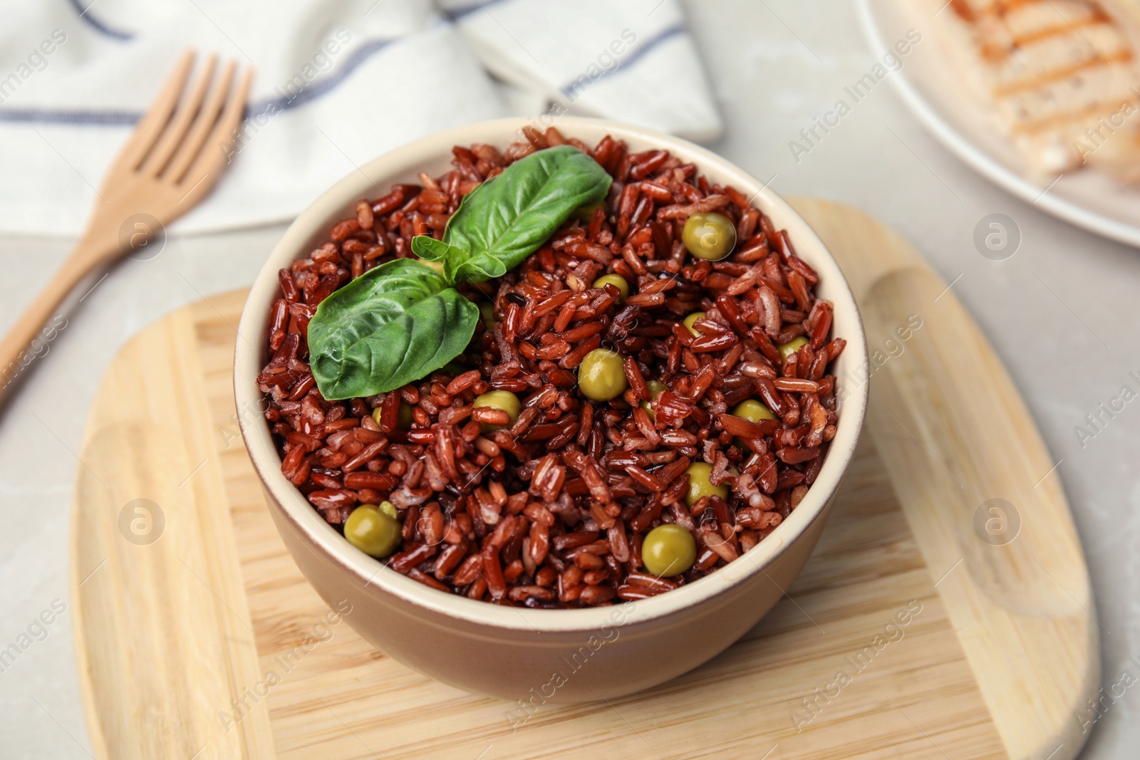 Photo of Bowl with delicious cooked brown rice on table