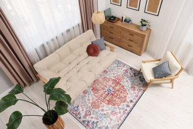 Photo of Beautiful rug, sofa, armchair and chest of drawers indoors, above view