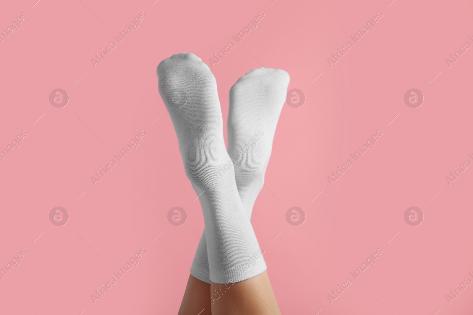 Photo of Woman in stylish white socks on pink background, closeup