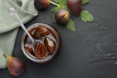 Jar of tasty sweet jam and fresh figs on black table, flat lay. Space for text