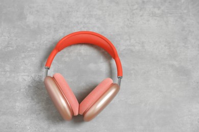 Photo of Stylish pink headphones on light grey table, top view. Space for text