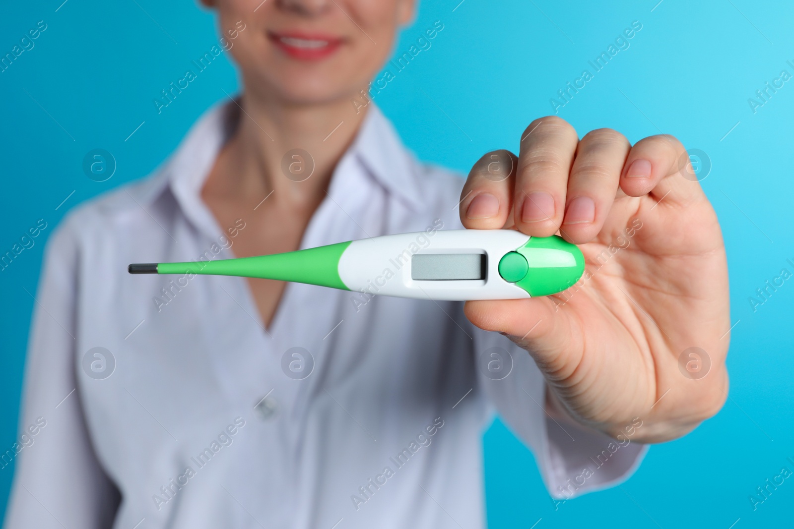 Photo of Female doctor holding digital thermometer on color background, closeup. Medical object