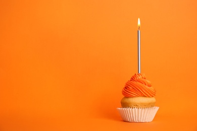 Photo of Birthday cupcake with candle on orange background, space for text