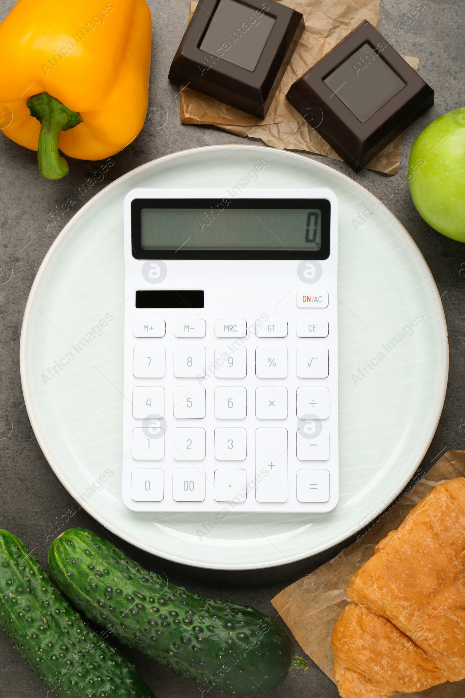 Photo of Calculator and food products on dark grey table, flat lay. Weight loss concept