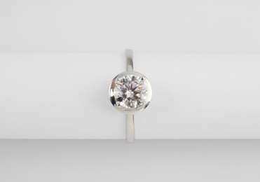 Photo of Beautiful engagement ring with gemstone on white background, top view