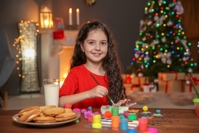 Little child painting Christmas tree of foam plastic at home