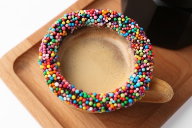 Photo of Delicious edible biscuit cup decorated with sprinkles on white table, closeup