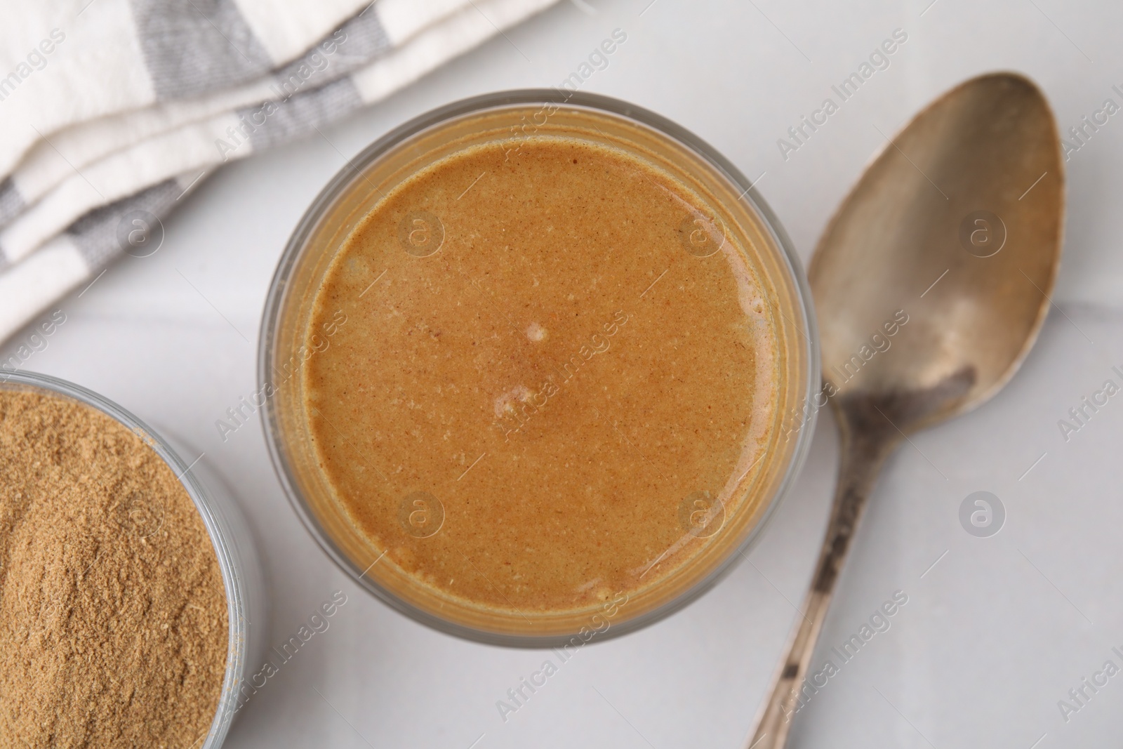 Photo of Soluble fiber with water in glass, powder and spoon on white table, top view