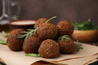 Photo of Delicious falafel balls and arugula on table