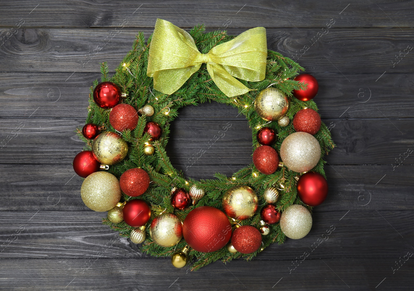 Photo of Beautiful Christmas wreath with festive decor on black wooden background