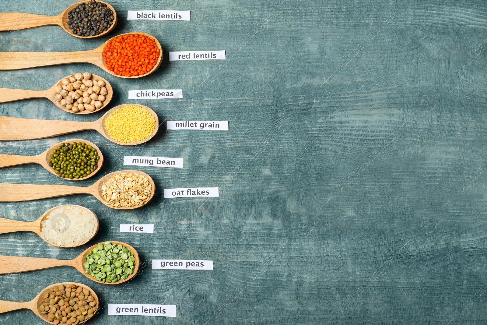 Photo of Flat lay composition with different types of legumes and cereals on blue wooden table, space for text. Organic grains