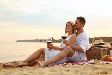 Photo of Happy romantic couple having picnic at beach