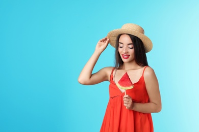 Photo of Beautiful young woman posing with watermelon on color background