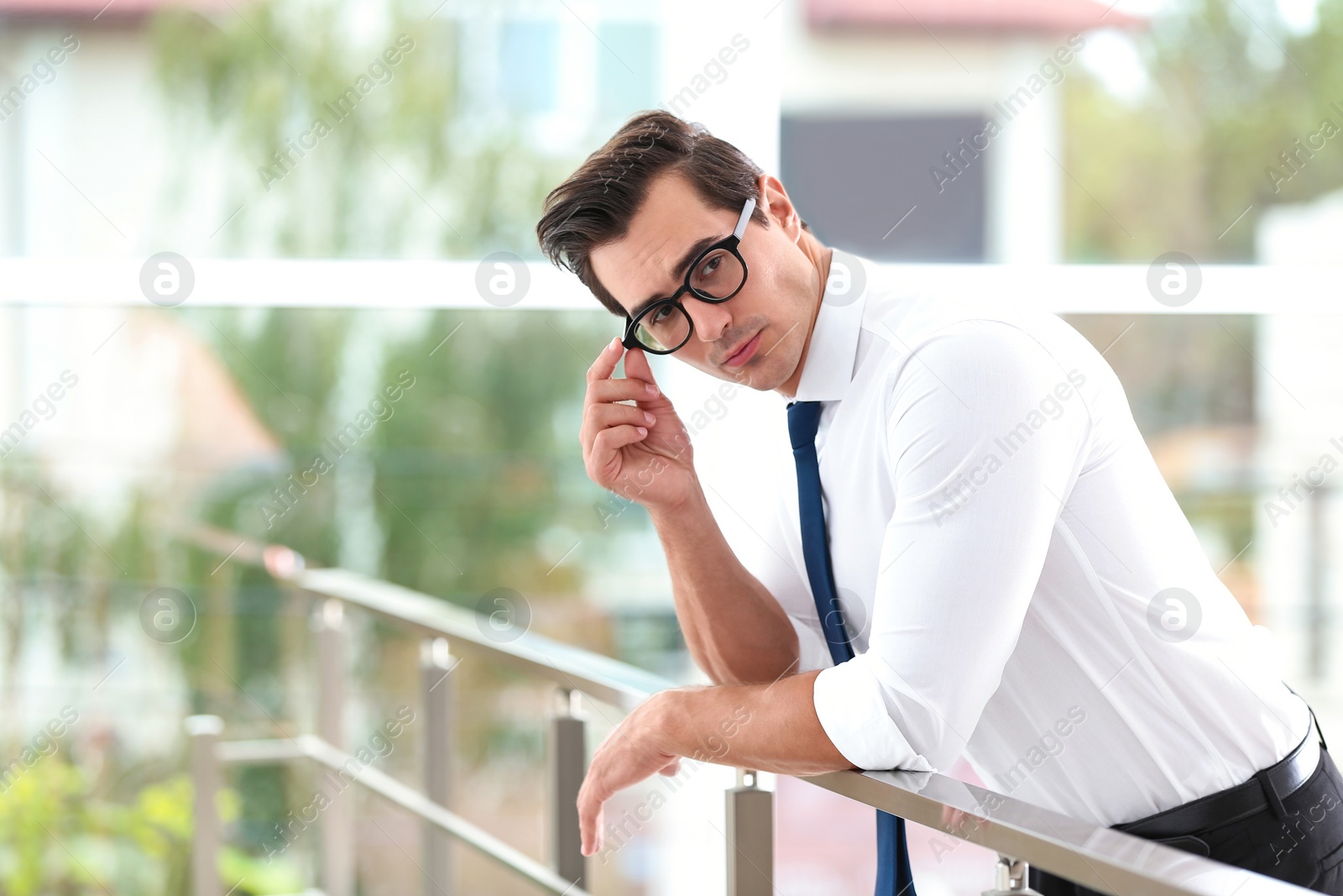 Photo of Handsome young man in stylish clothes with glasses indoors. Space for text