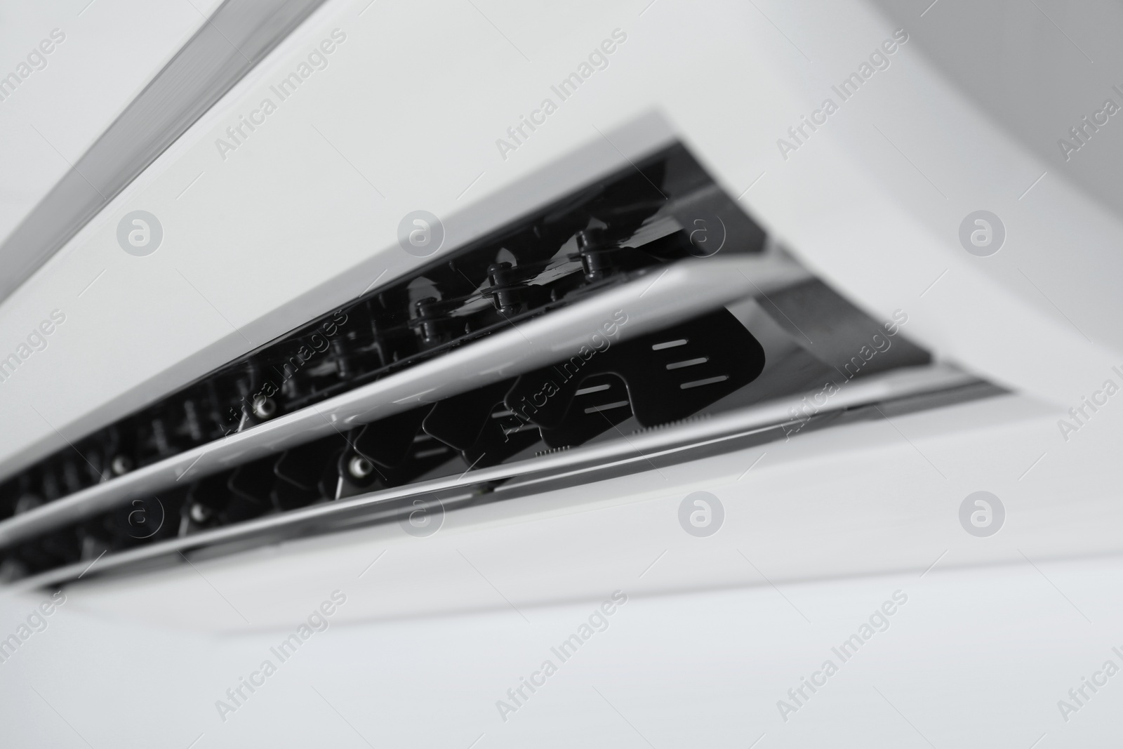 Photo of Modern air conditioner on white wall, closeup