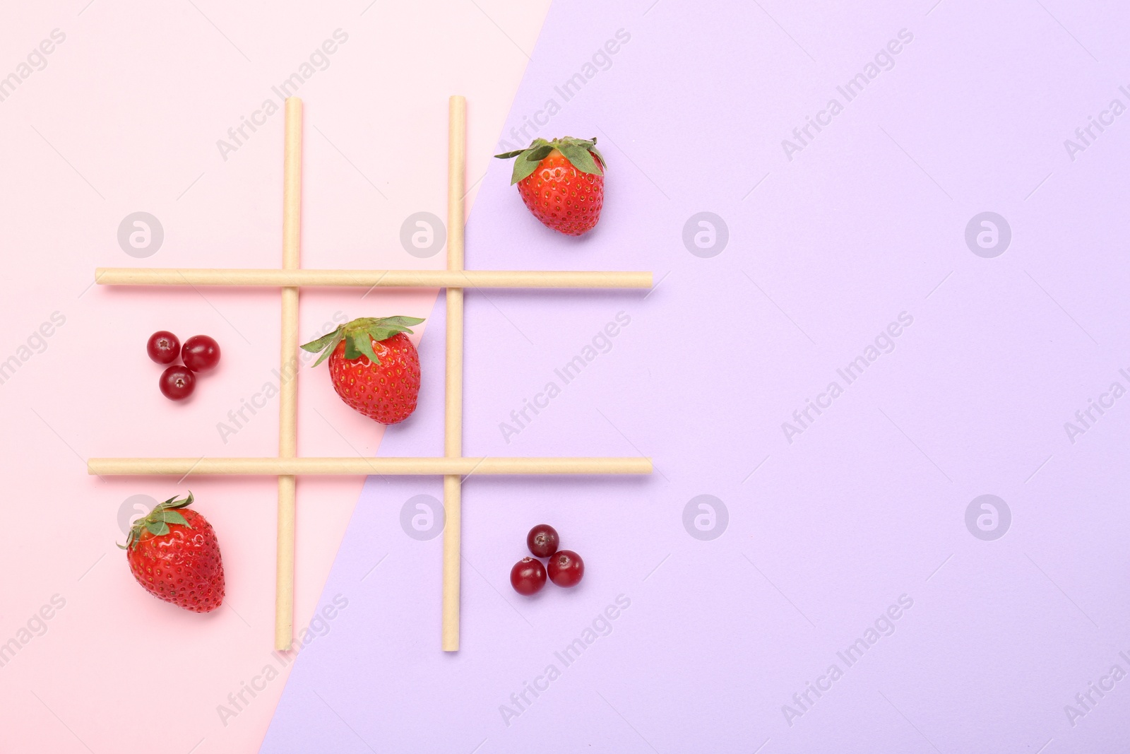 Photo of Tic tac toe game made with berries on color background, top view. Space for text