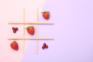 Photo of Tic tac toe game made with berries on color background, top view. Space for text