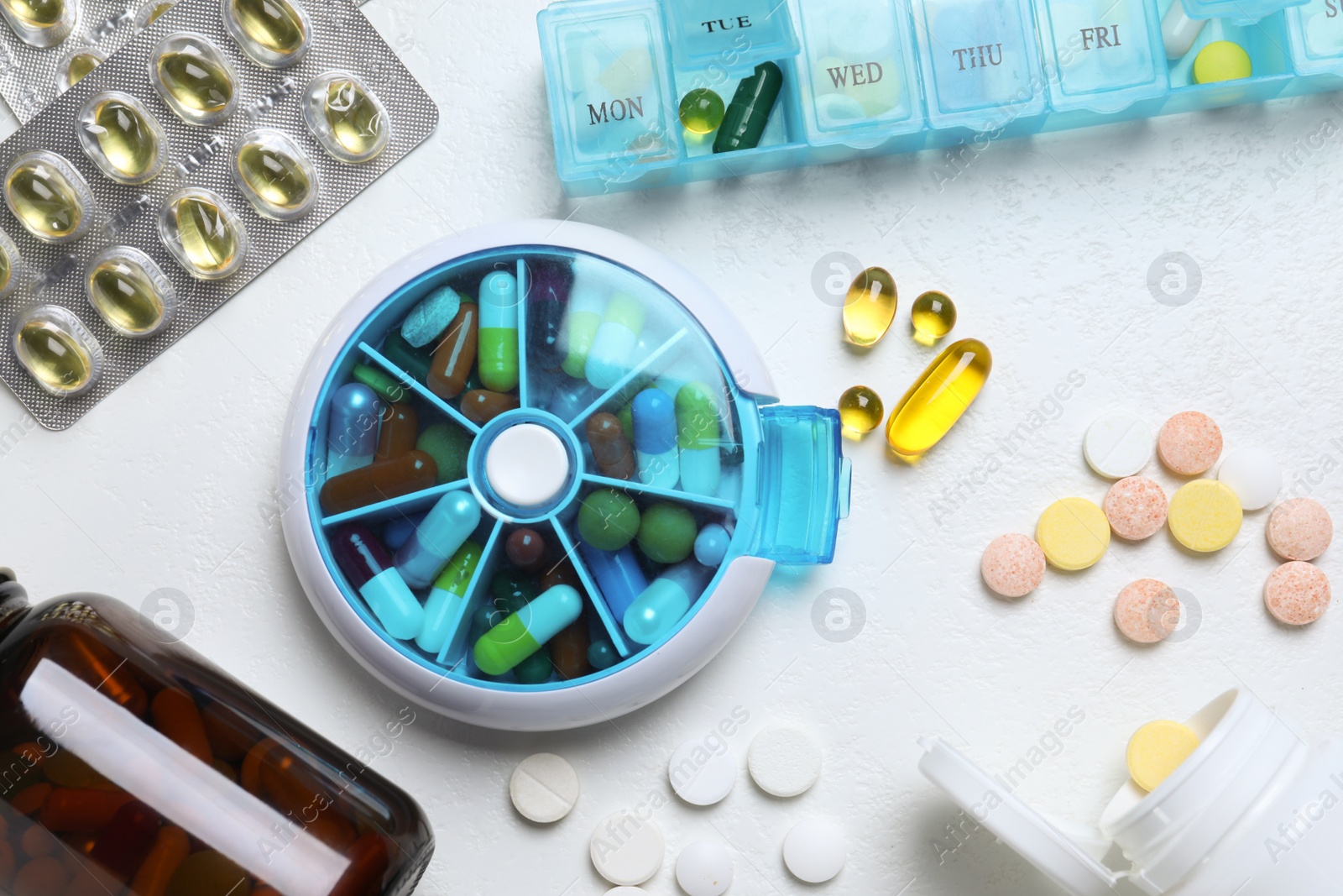 Photo of Pill boxes with medicaments on white table, flat lay