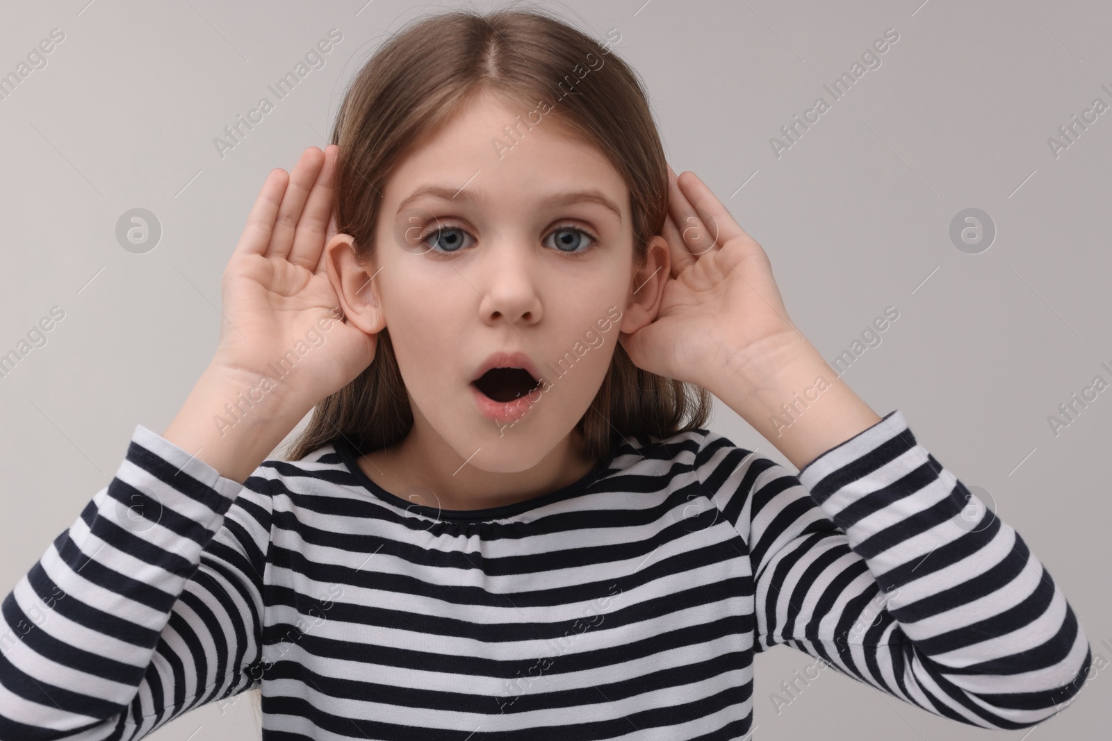 Photo of Little girl with hearing problem on grey background