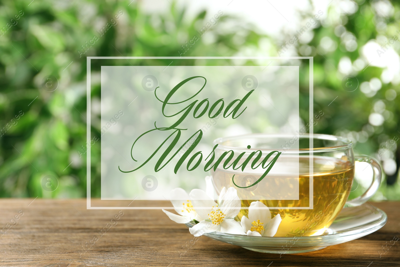 Image of Good morning. Glass cup of aromatic jasmine tea and fresh flowers on wooden table